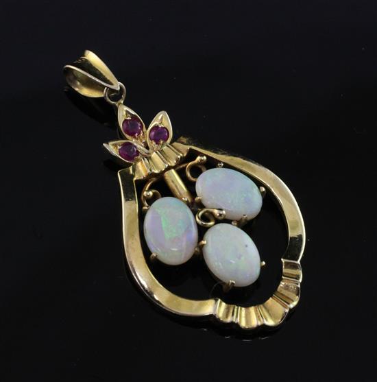 A 14ct gold, white opal and ruby pendant, 1.25in ex. bale.